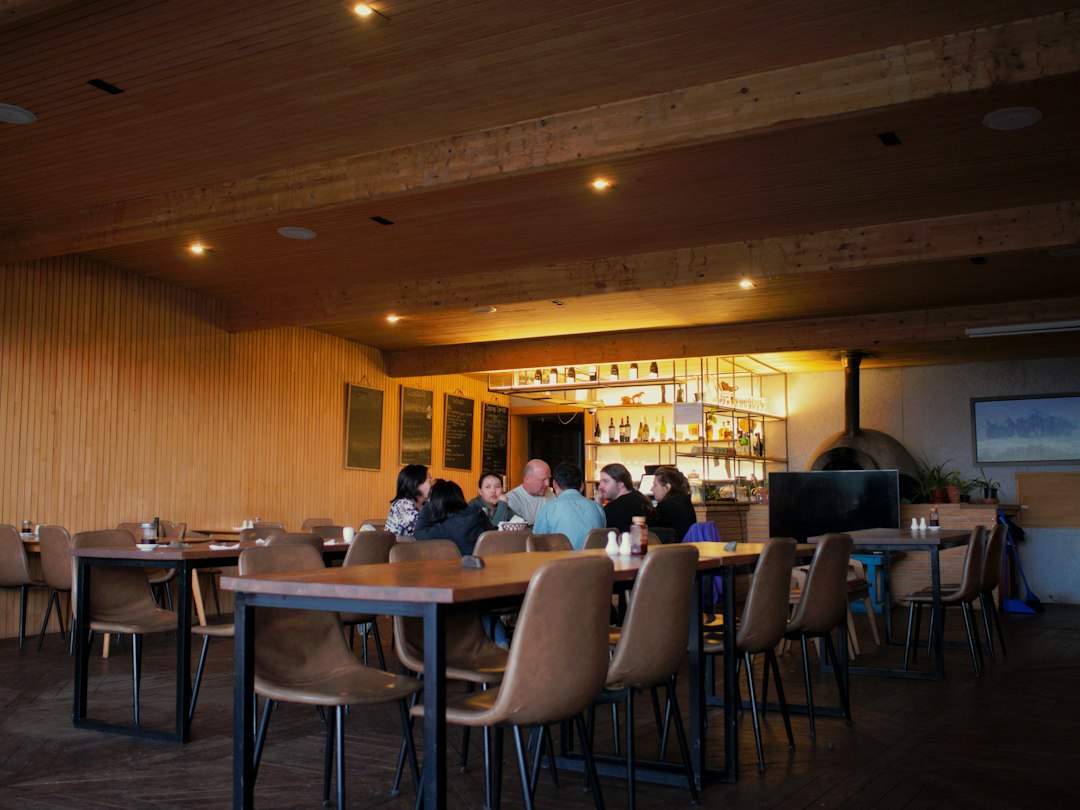 People dining in a cozy restaurant with a well-stocked bar
